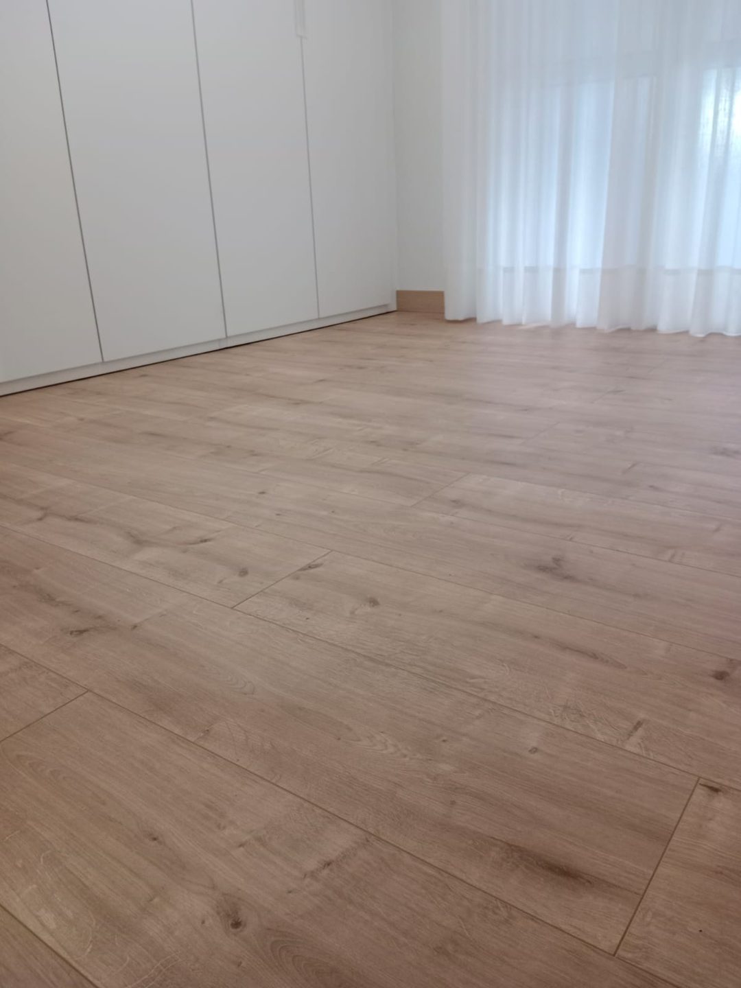 Dormitorio con armario blanco y cortinas