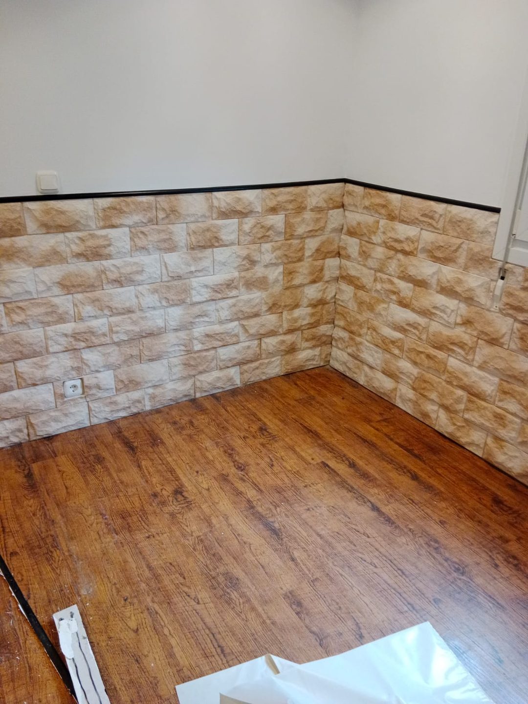 Salón con revestimiento de piedra y suelo laminado