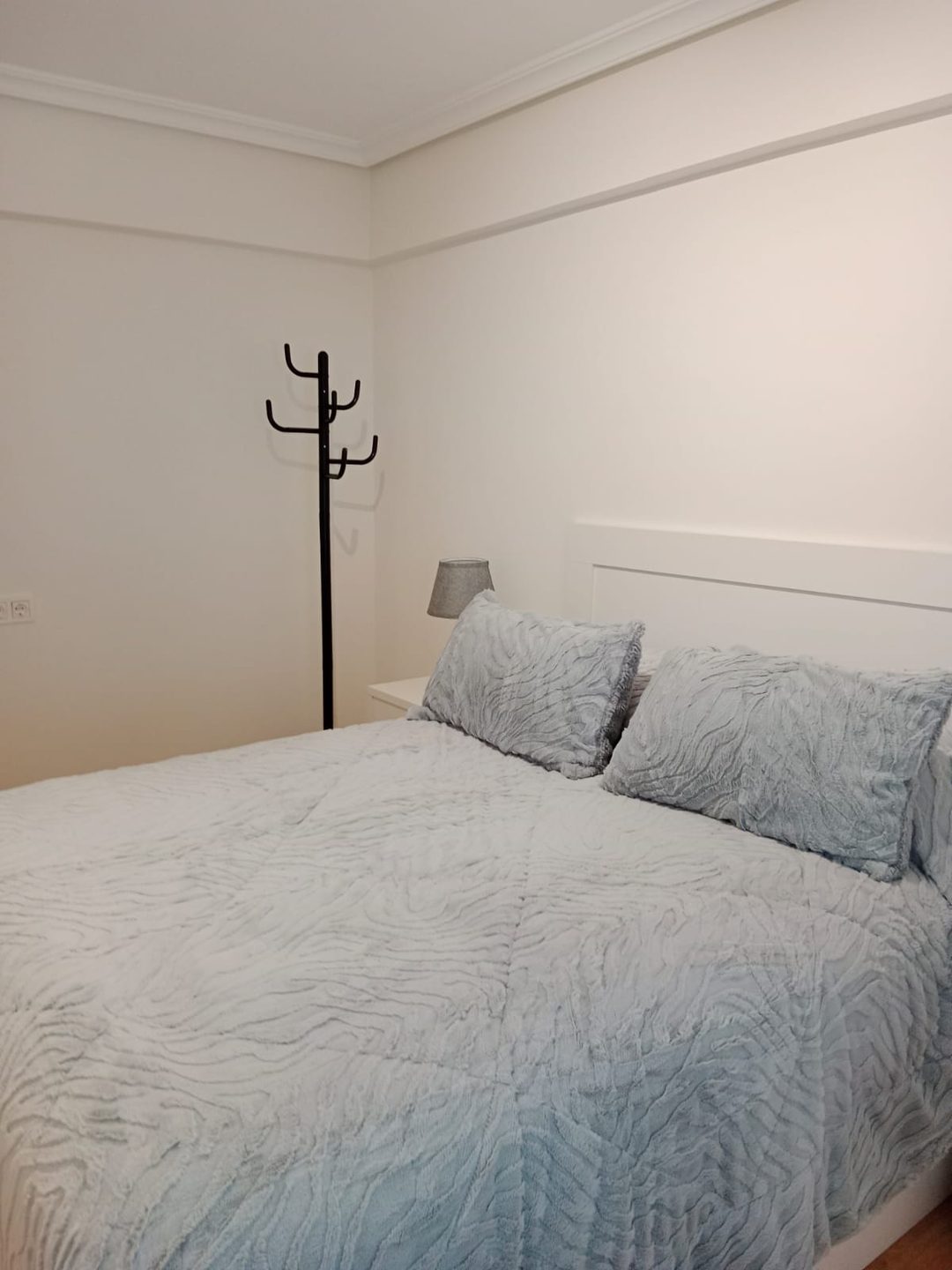 Dormitorio en tonos claros con suelo laminado