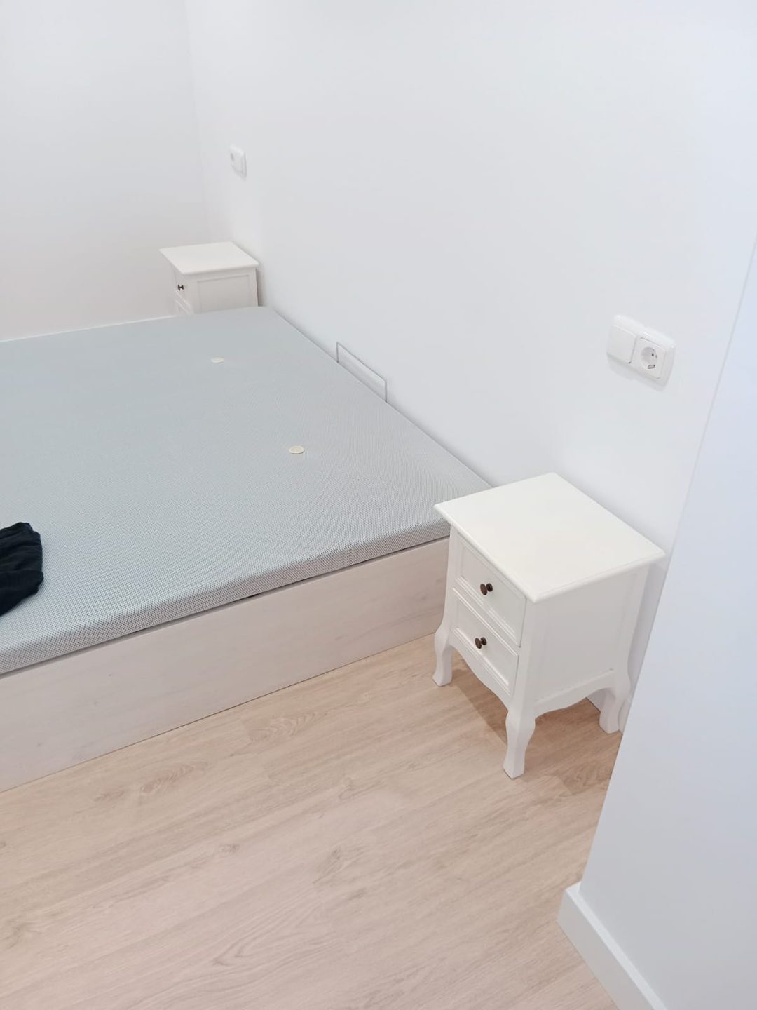 Dormitorio pintado con mesilla blanca